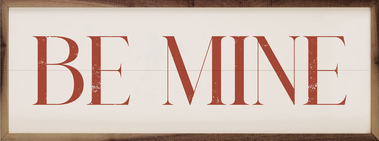Red "BE MINE" text on a white wood plank background with a natural walnut frame.