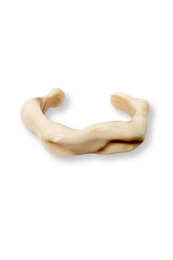 WS Isla Bangle, a chunky, sculptural open-bottom cuff with a marbled beige and brown finish.