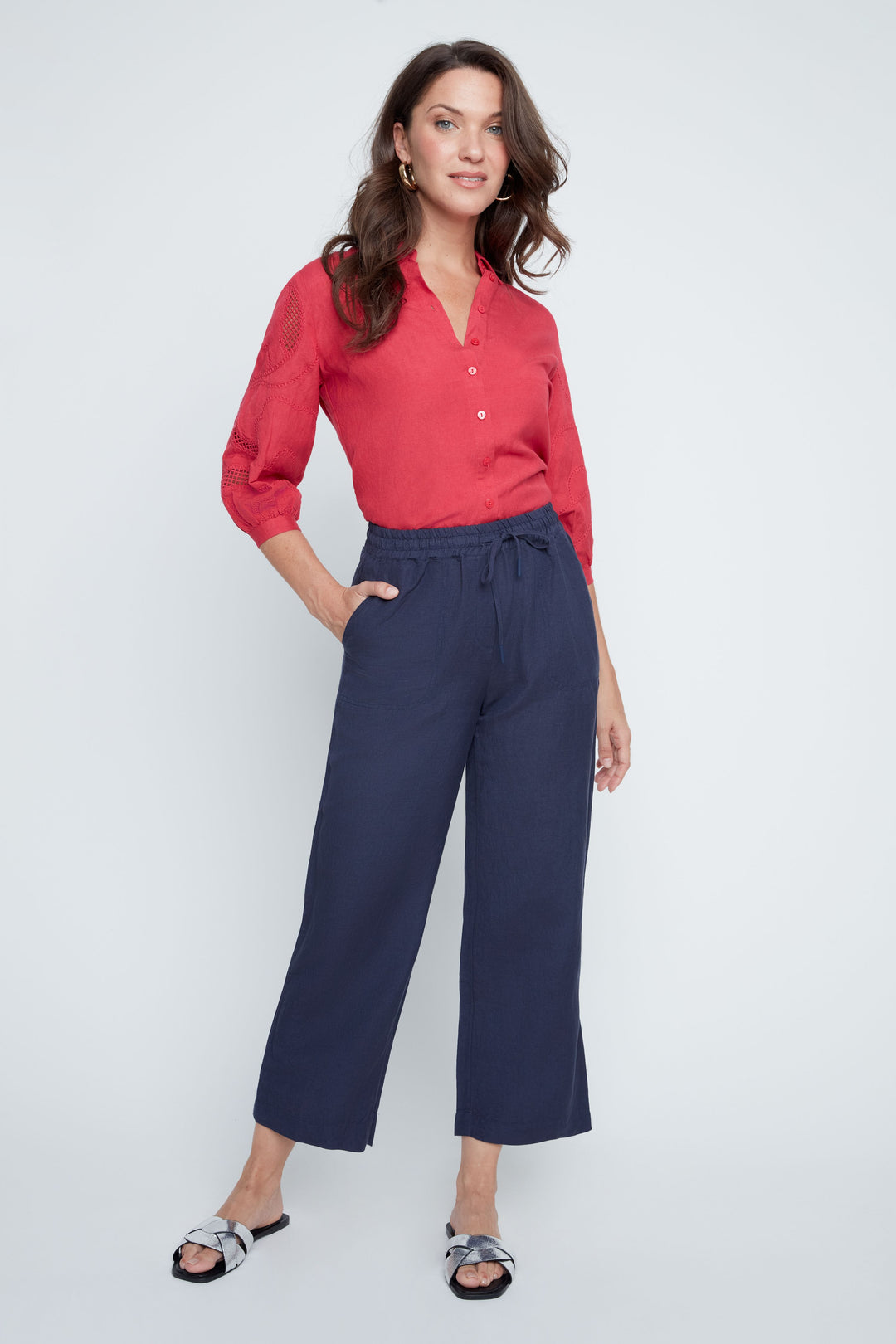 Woman wearing navy Victoria Woven Pants with a red blouse and silver sandals.