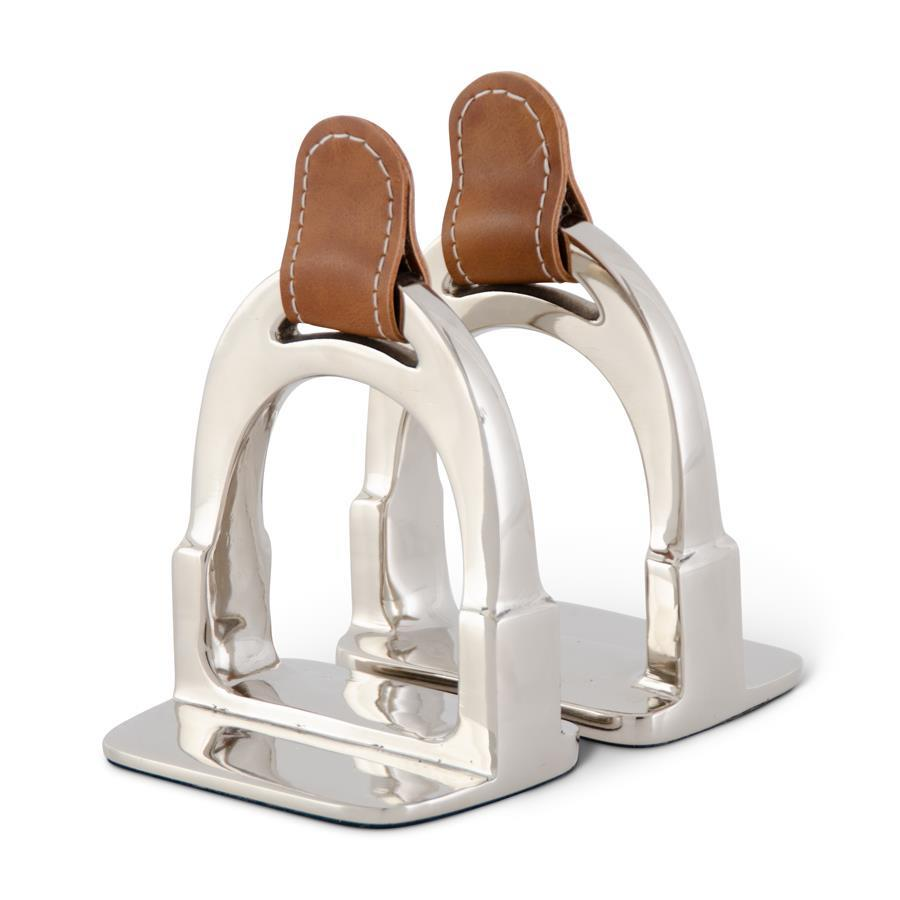 Set of two polished silver aluminum stirrup bookends with brown leather strap accents.