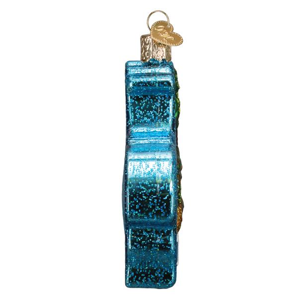 Side view of a blue glittery glass Hawaiian Islands ornament with a gold heart-shaped charm.