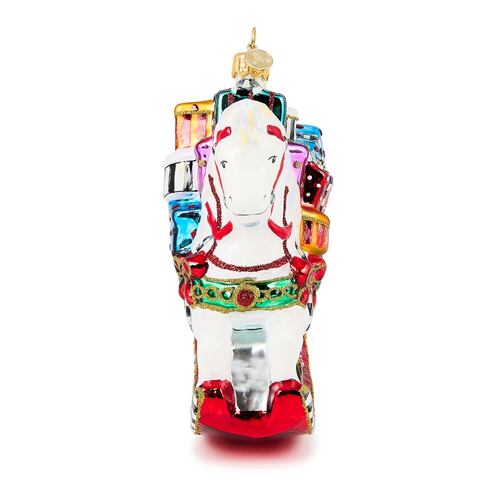 White rocking horse glass ornament with colorful gift boxes on its back and red rockers.