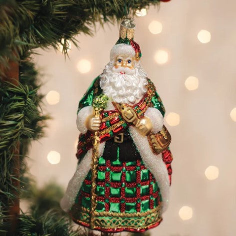 Irish Father Christmas glass ornament wearing a green and red plaid kilt and holding a staff.