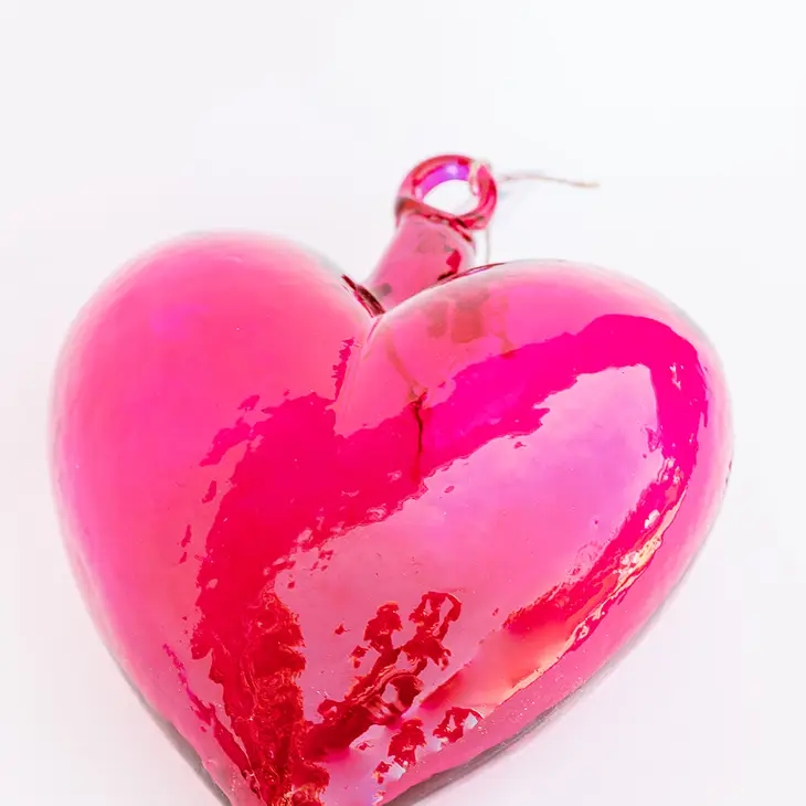 Hand-blown glass heart pendant in translucent amber with smooth organic curves.