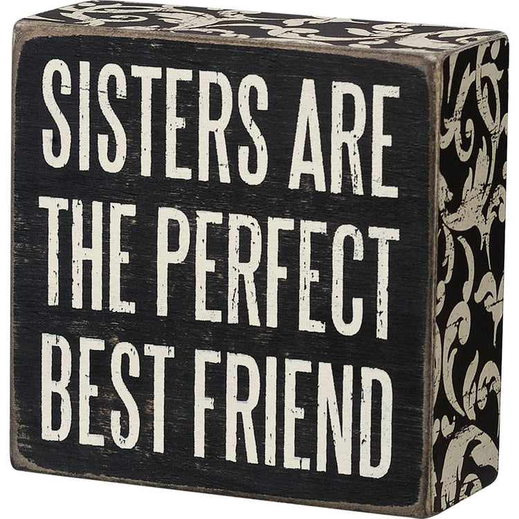 Black wooden box sign with white text reading "SISTERS ARE THE PERFECT BEST FRIEND".