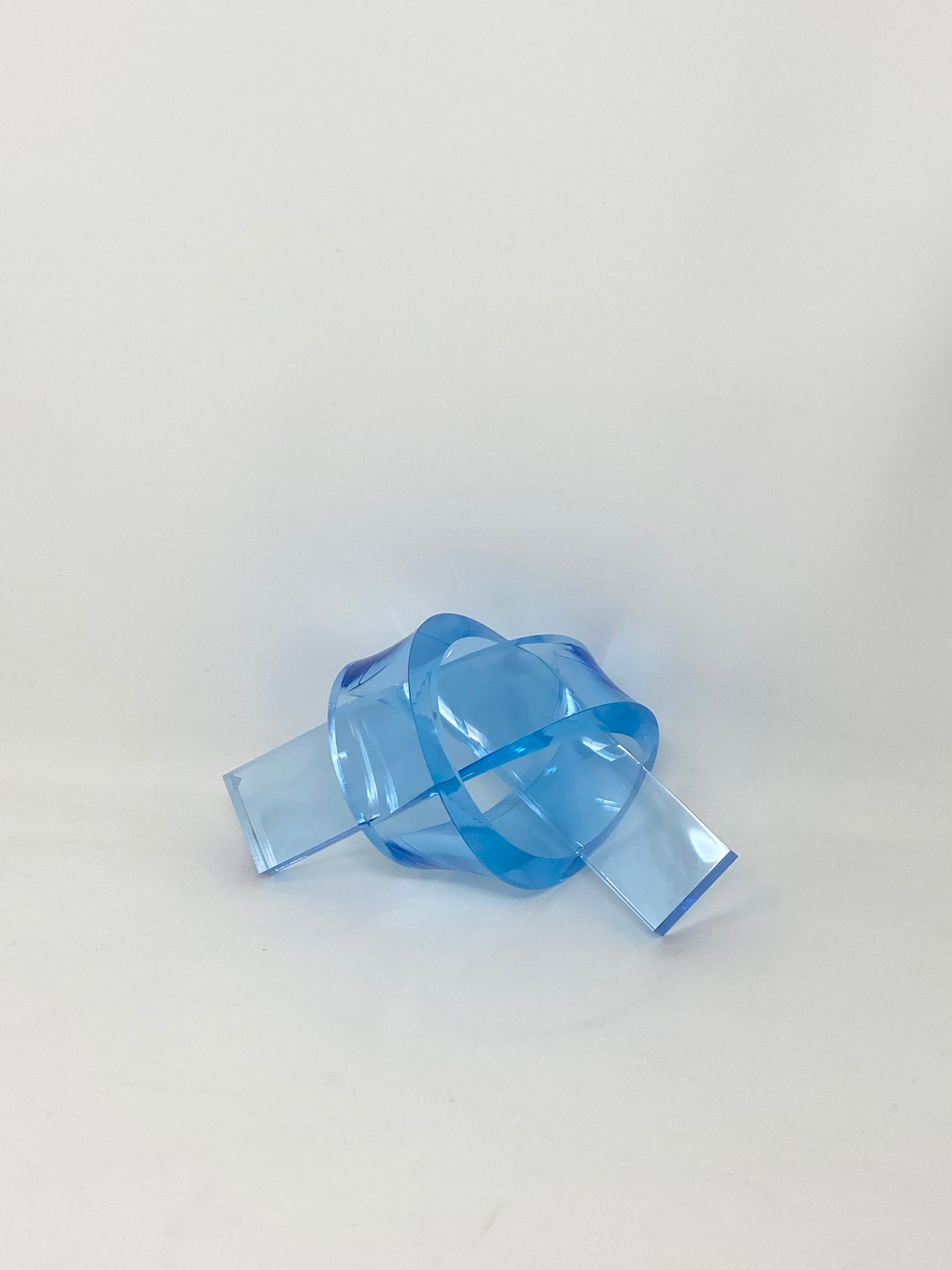 Acrylic knot pendant in clear acrylic with a knotted chain link detail.
