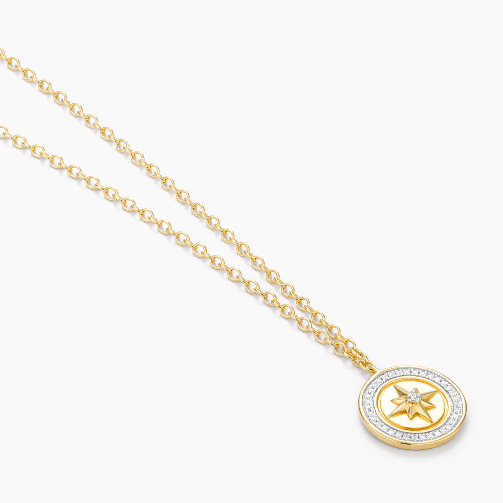 Sterling silver compass pendant necklace with gold-plated finish on a chain