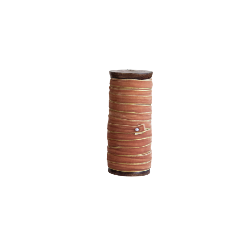 10-yard terracotta velvet ribbon with metallic edges wrapped on a dark wood spool.