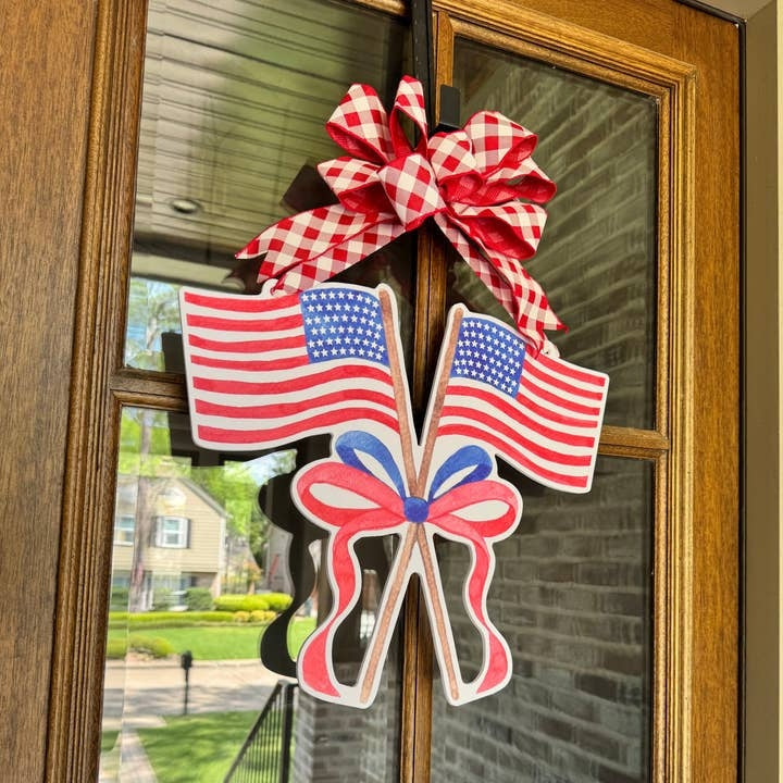 Sweet Land of Liberty Flags Door Hanger with two crossed American flags and a red gingham bow.