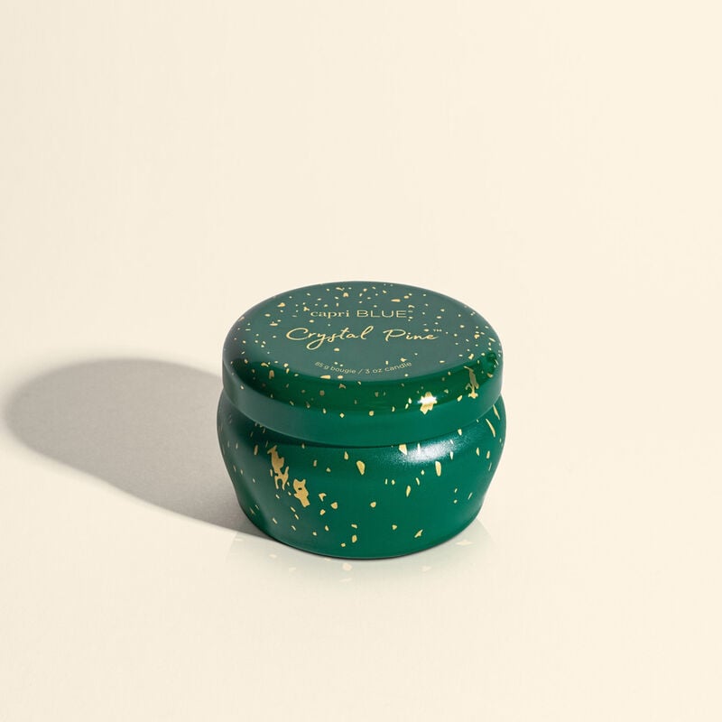 Mini tin candle in Crystal Pine Glimmer with a clear glass jar containing white wax and pine-scented wicks.