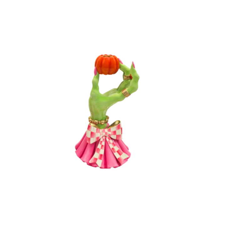 Green witch hand candle holder with pink nails, gold jewelry, and a pink checkered bow.