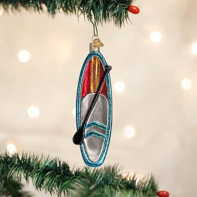 Blue glass stand up paddle board Christmas ornament with a red and silver deck and black paddle.