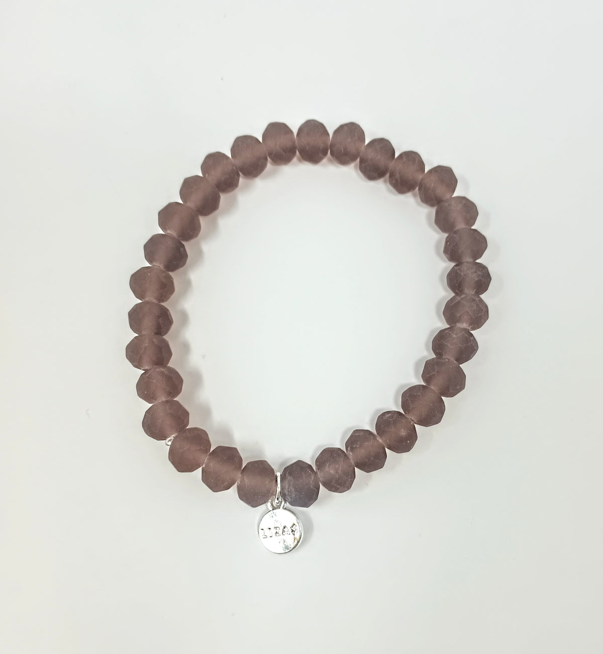 Stretchy bracelet with faceted matte purple glass beads and a small silver logo charm.