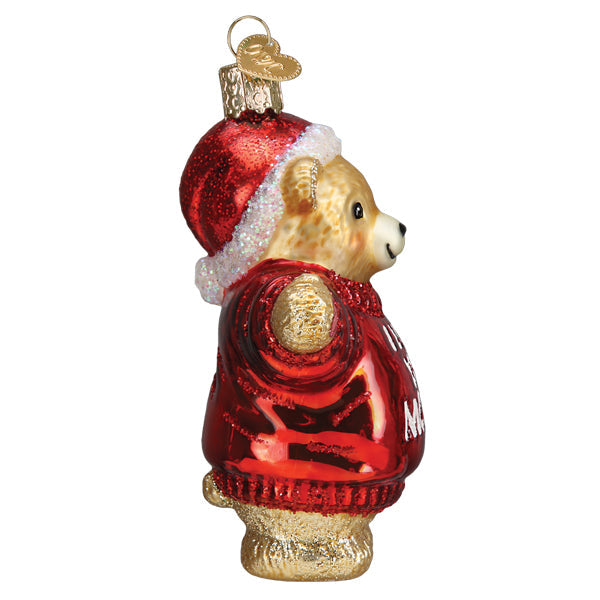 Side view of a glass bear ornament wearing a red Santa hat and a red sweater.