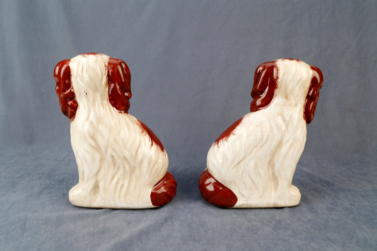 Pair of Staffordshire dog figurines with flower baskets in black ceramic.